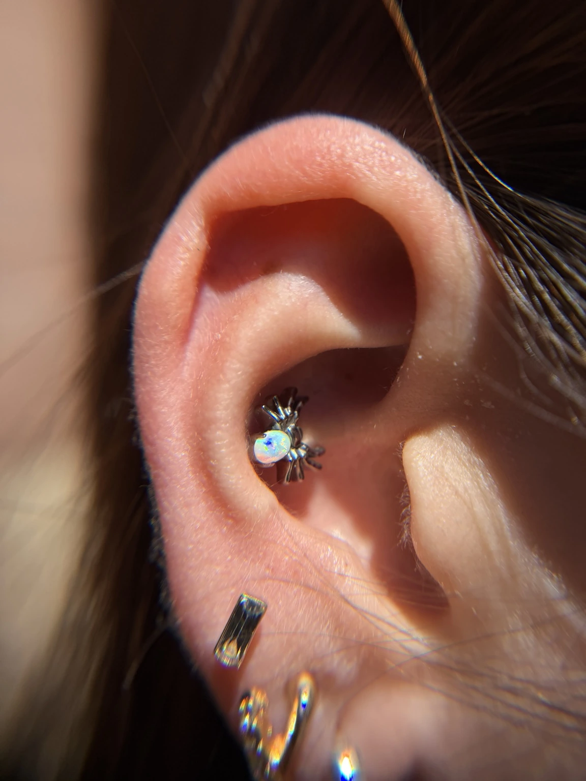 Finished ear piercings with an opal detail