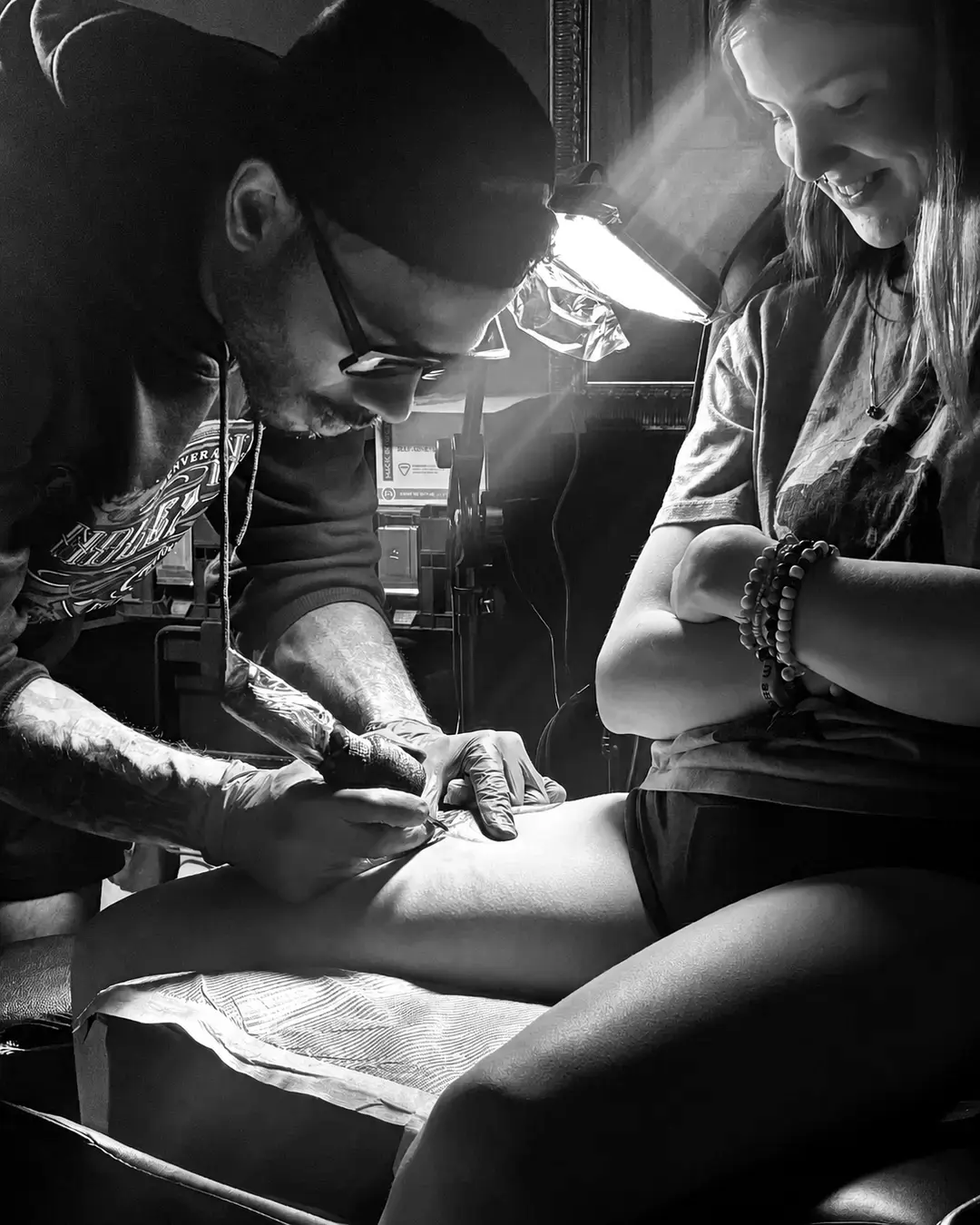 Artist tattooing a client's leg at Endless Ink